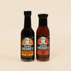 Two bottles of Corporal Freddie's sauce on a beige background