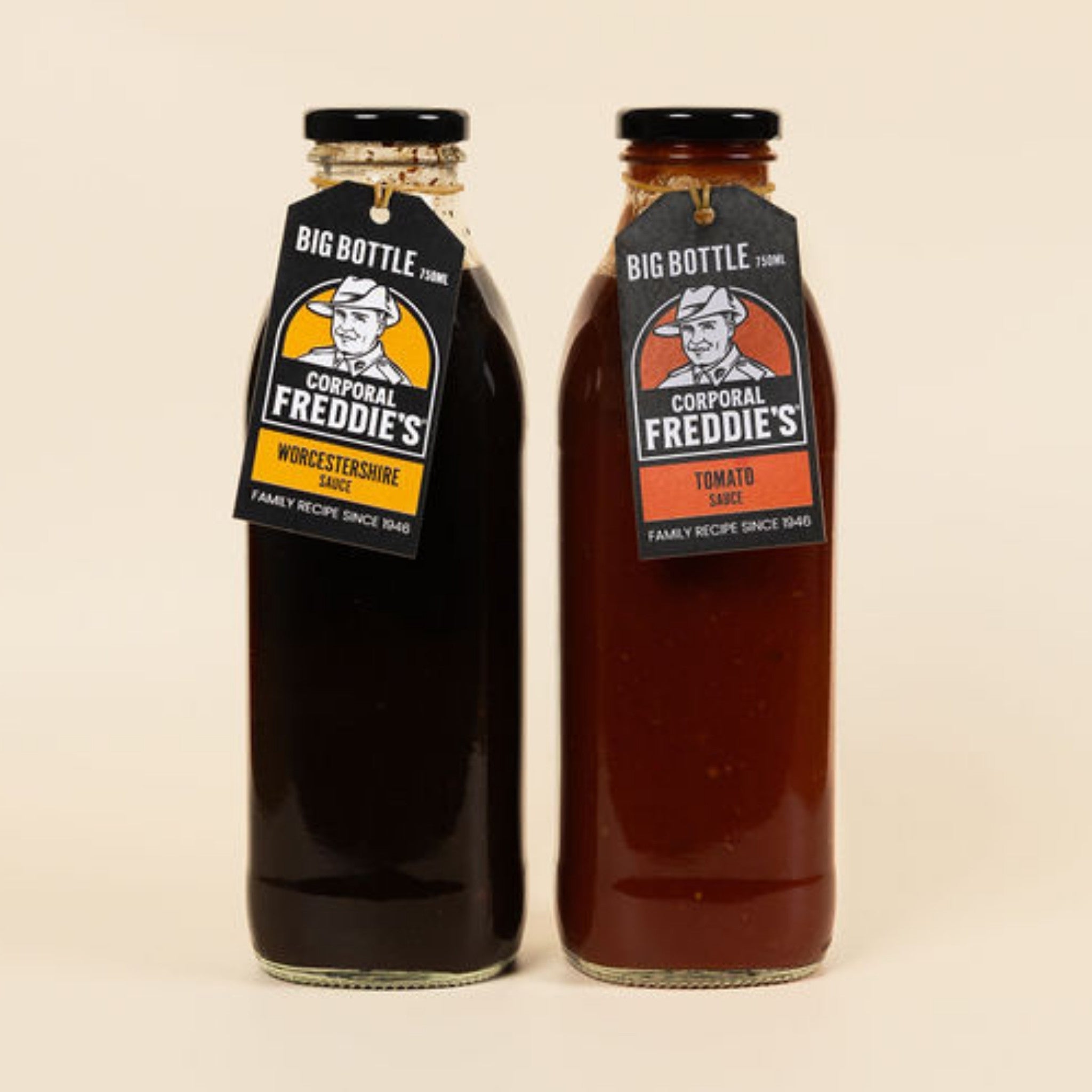 Two bottles of Corporal Freddie's sauce with labels on a beige background