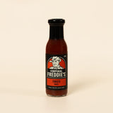Bottle of Corporal Freddie's Tomato Sauce on a beige background